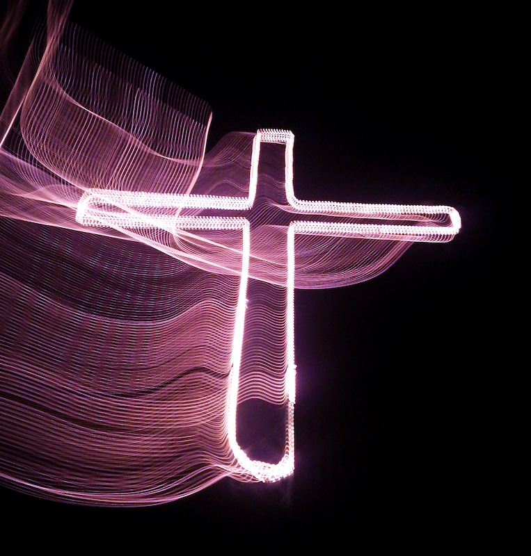 Photo d'une croix chrétienne rose avec effet de lumière